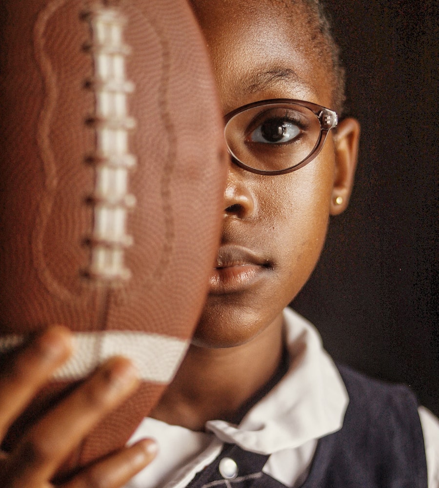 Young player holding an american football close to the camera