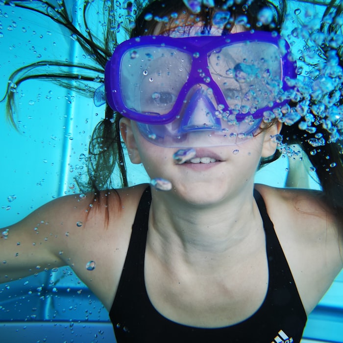 Girl swimming underwater with a mask